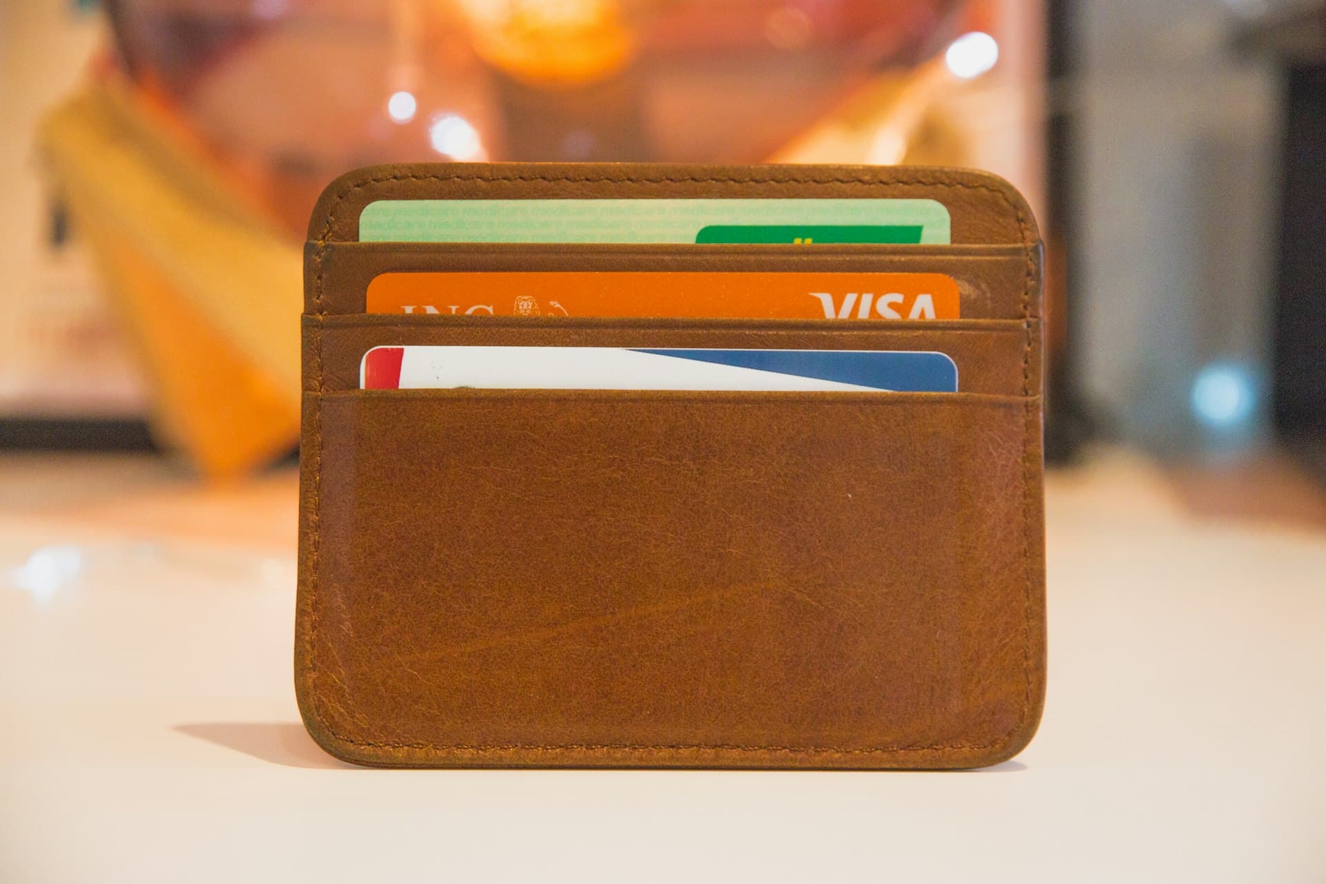 Slim brown leather card holder with several credit cards