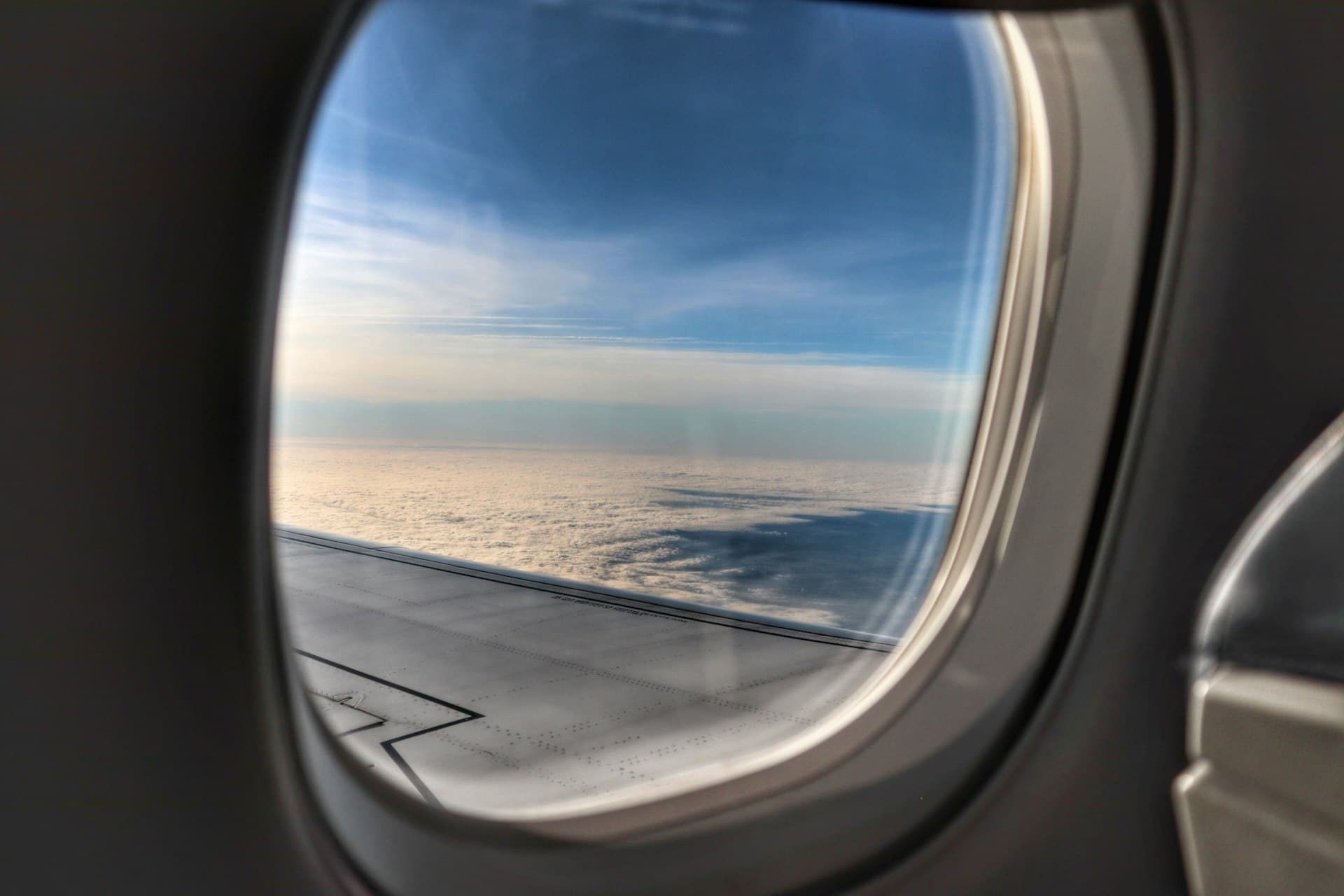 View of clouds and an aircraft wing from an airplane window
