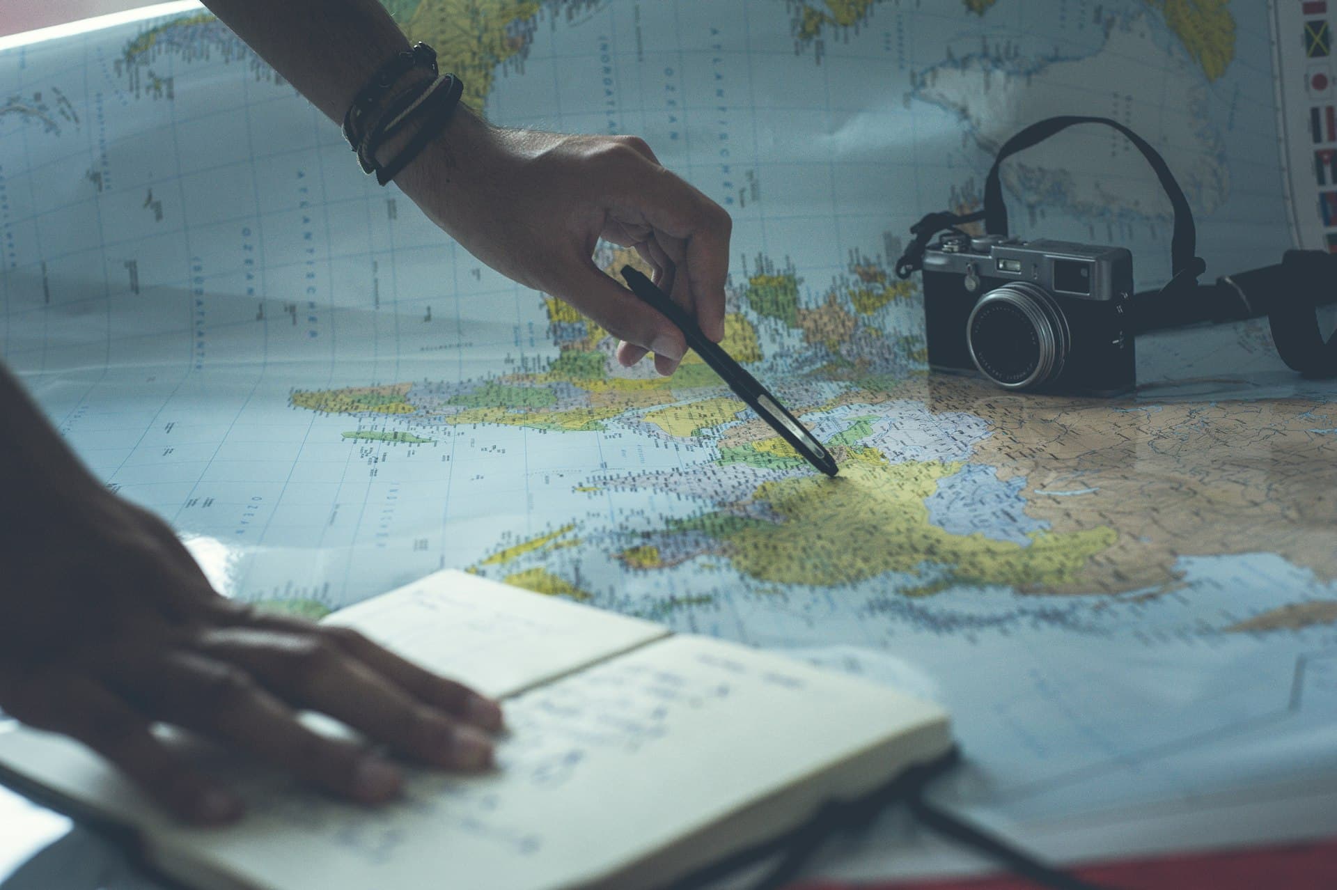 Person planning a trip, writing notes at a desk